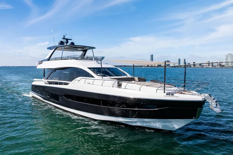 Slide: The Image of 2021 Azimut Fly 78 yacht cruising on blue water with city skyline in background. - 61