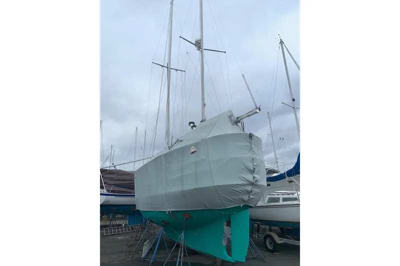Slide: The Image of 1980 Cheoy Lee 43 Pilot House sailboat covered and docked in a marina. - 98
