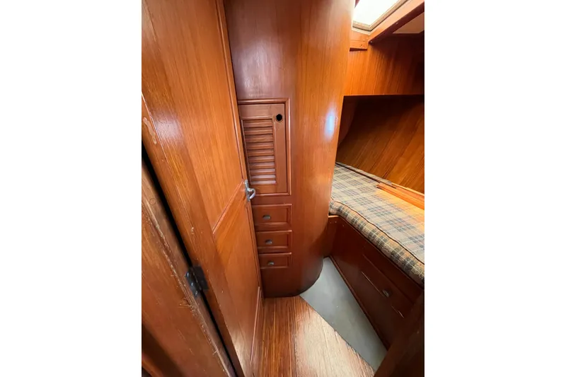Slide: The Image of Interior of 1980 Cheoy Lee 43 Pilot House with wooden cabinetry and plaid bedding. - 83