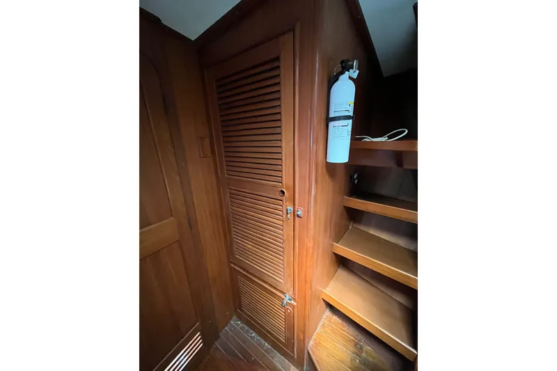 Slide: The Image of Wooden interior of 1980 Cheoy Lee 43 Pilot House with fire extinguisher and shelves. - 66