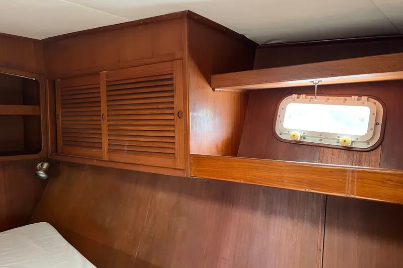 Slide: The Image of Interior of 1980 Cheoy Lee 43 Pilot House with wooden cabinetry and porthole window. - 64