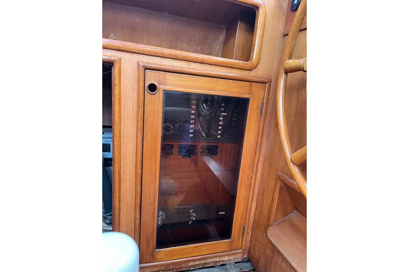 Slide: The Image of 1980 Cheoy Lee 43 Pilot House control panel with wooden cabinetry and steering wheel. - 97
