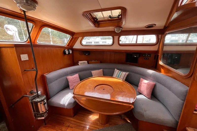 Slide: The Image of 1980 Cheoy Lee 43 Pilot House interior with curved seating and wooden table. - 74