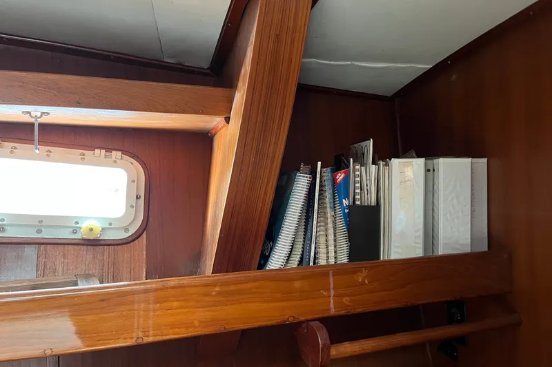 Slide: The Image of Wooden interior shelf with binders and notebooks on a 1980 Cheoy Lee 43 Pilot House. - 62