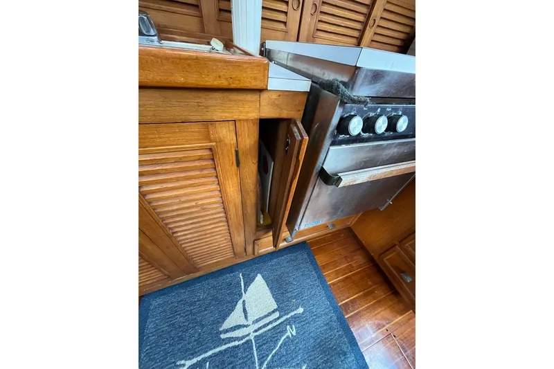 Slide: The Image of 1980 Cheoy Lee 43 Pilot House kitchen with wooden cabinets and stainless steel stove. - 48