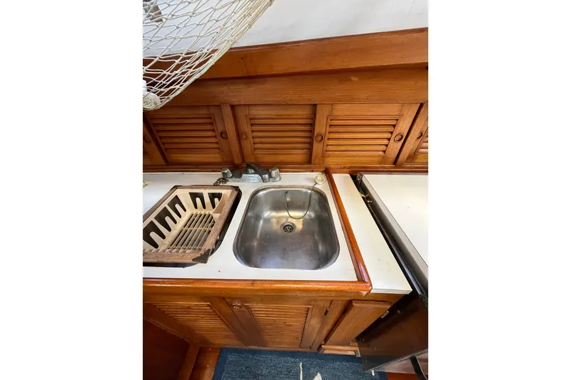 Slide: The Image of 1980 Cheoy Lee 43 Pilot House kitchen sink with wooden cabinetry and drying rack. - 53