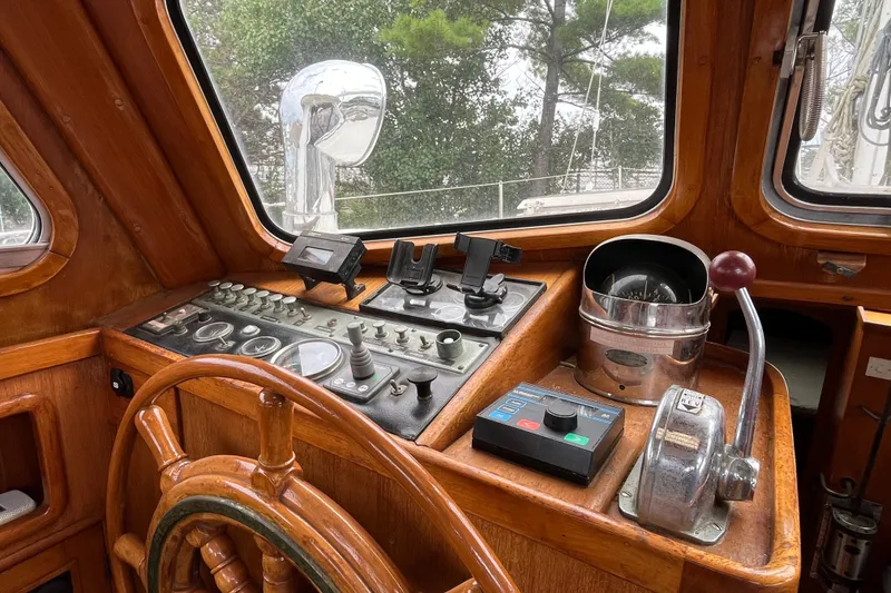 Slide: The Image of 1980 Cheoy Lee 43 Pilot House helm with wooden wheel and navigation controls. - 29