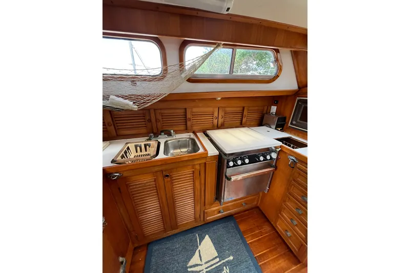 Slide: The Image of 1980 Cheoy Lee 43 Pilot House kitchen with wooden cabinets, stove, and sink. - 47