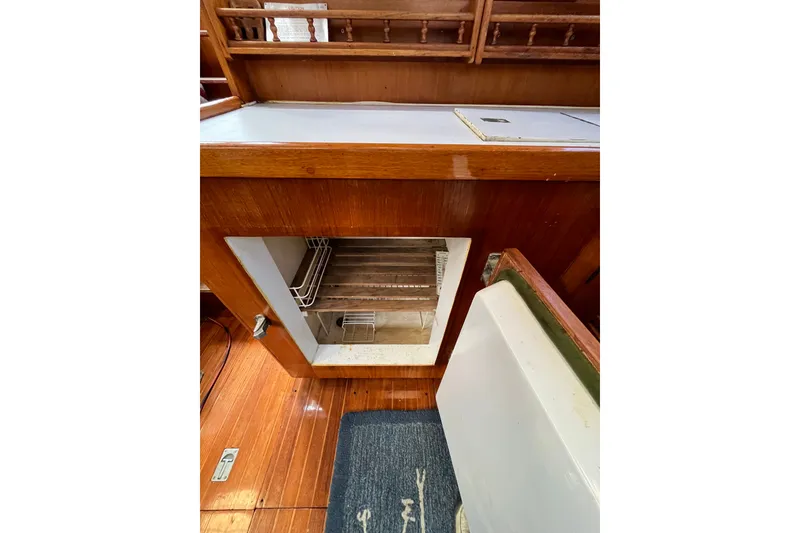 Slide: The Image of Interior view of 1980 Cheoy Lee 43 Pilot House showing open wooden cabinet and refrigerator. - 51