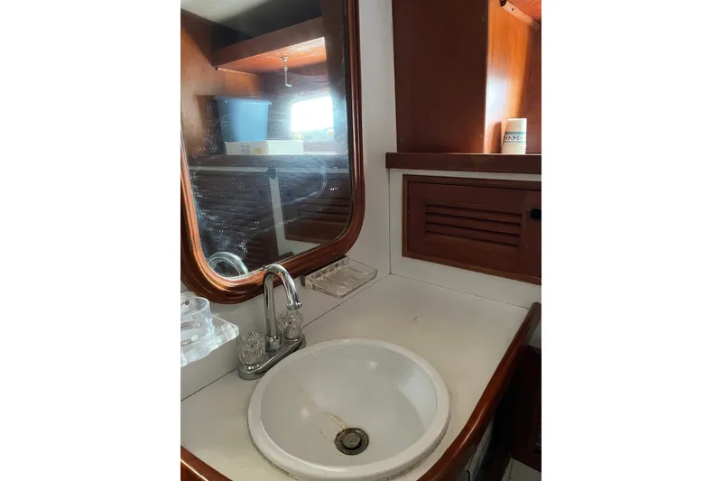 Slide: The Image of 1980 Cheoy Lee 43 Pilot House bathroom with sink, mirror, and wooden cabinetry. - 71