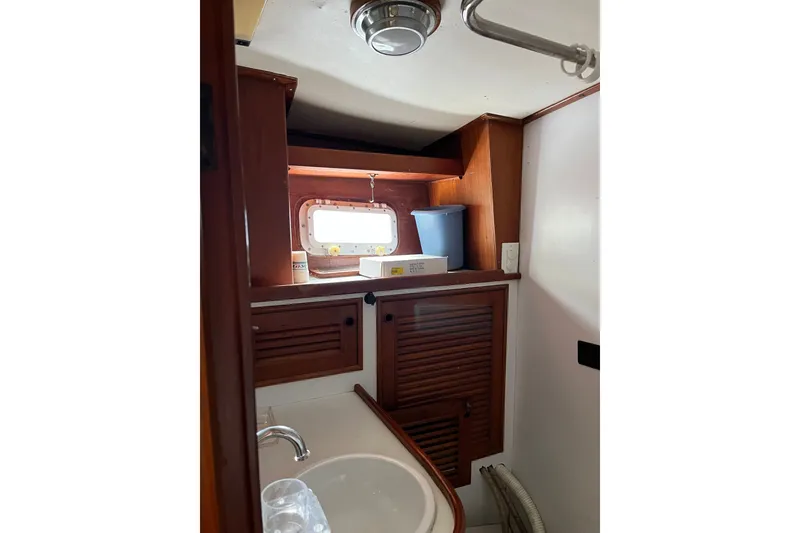 Slide: The Image of Interior of 1980 Cheoy Lee 43 Pilot House, featuring wooden cabinetry and a small window. - 72