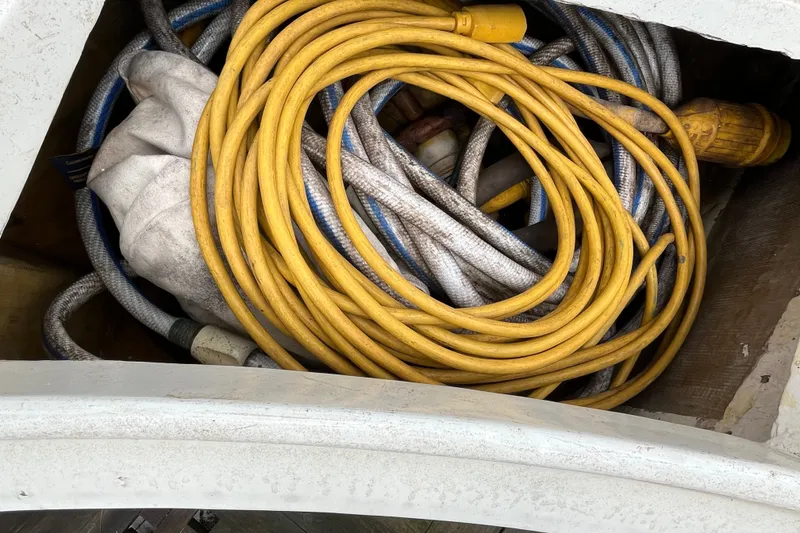 Slide: The Image of Coiled yellow and white ropes in storage on 1980 Cheoy Lee 43 Pilot House. - 23