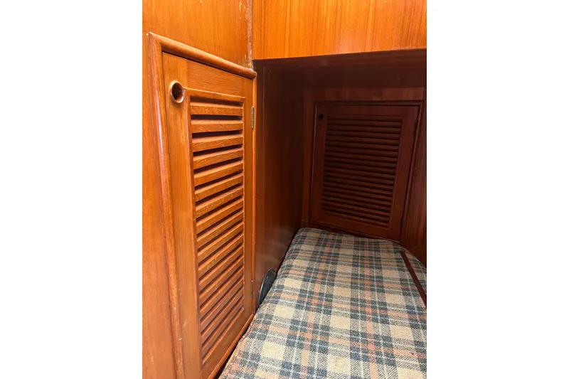 Slide: The Image of Interior of 1980 Cheoy Lee 43 Pilot House with wooden cabinetry and plaid upholstery. - 87