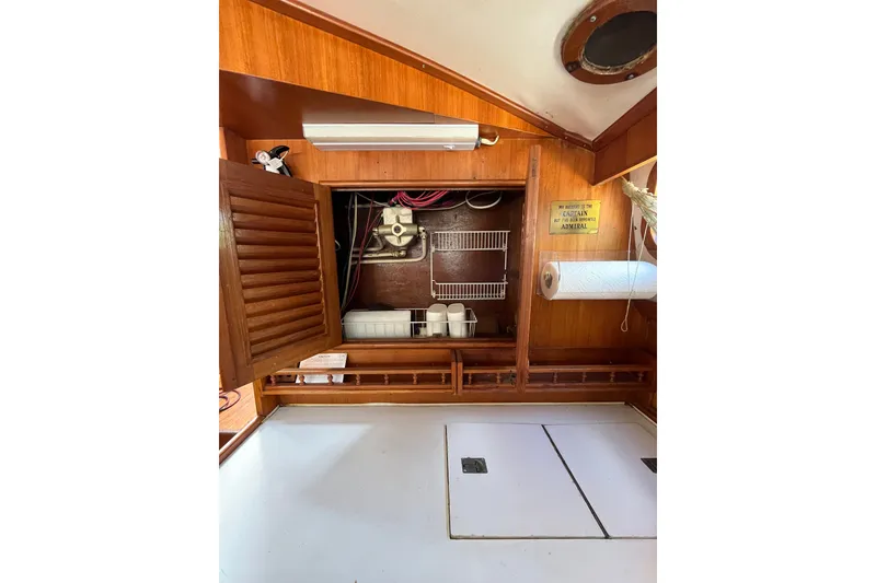 Slide: The Image of Interior of 1980 Cheoy Lee 43 Pilot House with open wooden cabinet and storage shelves. - 43