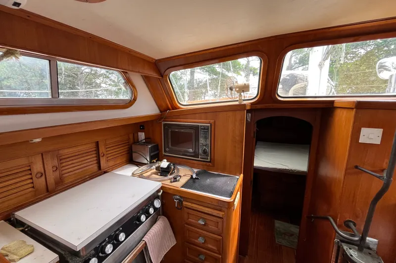 Slide: The Image of Interior of 1980 Cheoy Lee 43 Pilot House with wood cabinetry and kitchen area. - 46
