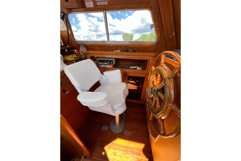 Slide: The Image of 1980 Cheoy Lee 43 Pilot House interior with captain's chair and wooden steering wheel. - 31