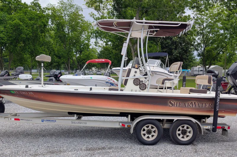 The Image of 2010 ShearWater 2200X boat on trailer, parked outdoors with trees in background. - 1