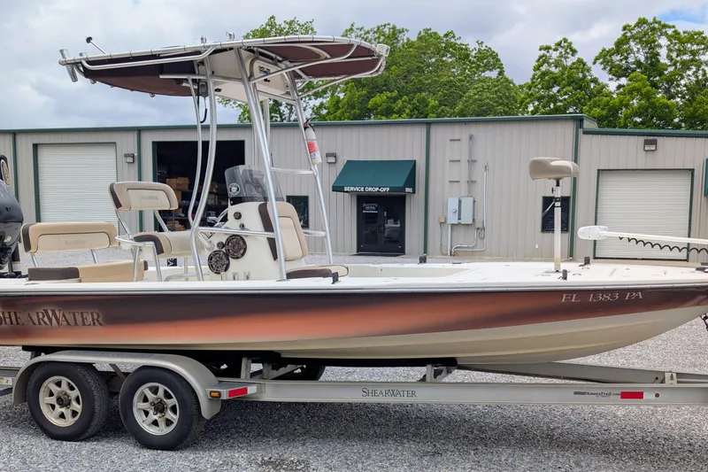 Slide: The Image of 2010 ShearWater 2200X boat on trailer, parked outside service shop. - 2