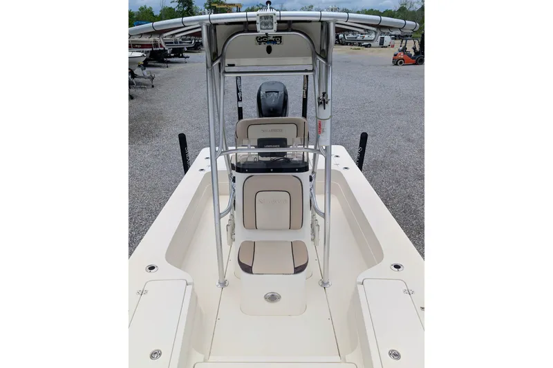 Slide: The Image of 2010 ShearWater 2200X boat interior with seating and console, parked in a marina. - 6
