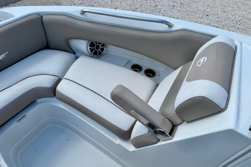 Slide: The Image of 2023 Crownline Eclipse E235 XS boat interior with cushioned seating and speaker. - 12