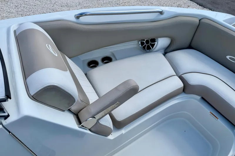 Slide: The Image of 2023 Crownline Eclipse E235 XS boat interior with cushioned seating and speaker. - 13