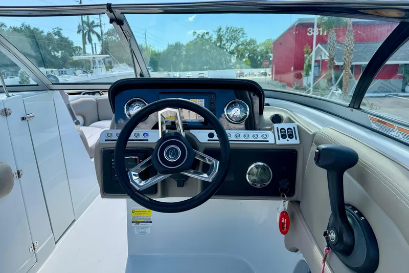 Slide: The Image of 2023 Crownline Eclipse E235 XS boat dashboard with steering wheel and controls. - 14