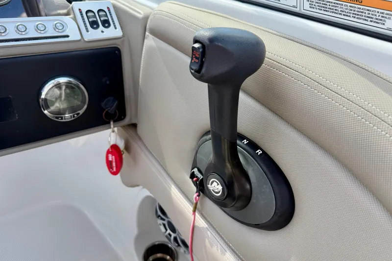 Slide: The Image of 2023 Crownline Eclipse E235 XS boat control panel with throttle lever and ignition key. - 21