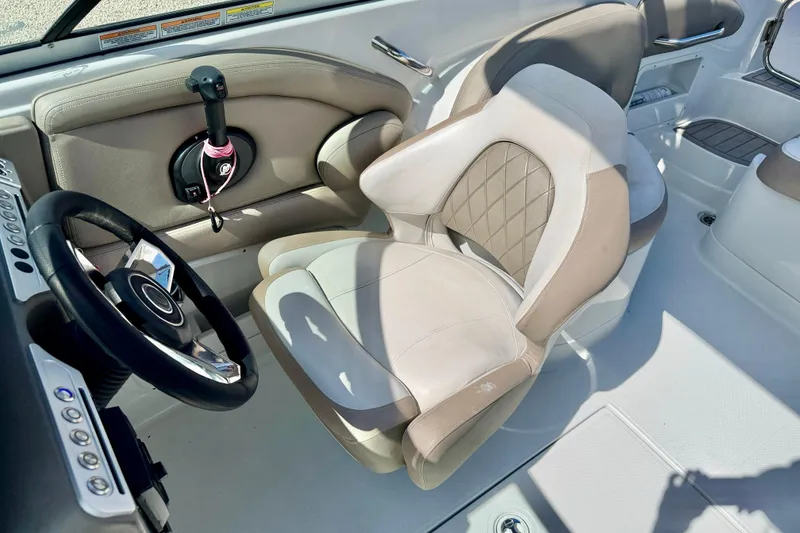 Slide: The Image of 2023 Crownline Eclipse E235 XS boat interior with steering wheel and plush seating. - 24