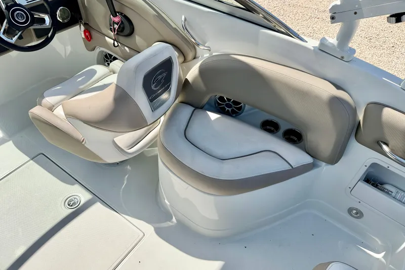 Slide: The Image of 2023 Crownline Eclipse E235 XS boat interior with beige seating and steering wheel. - 27