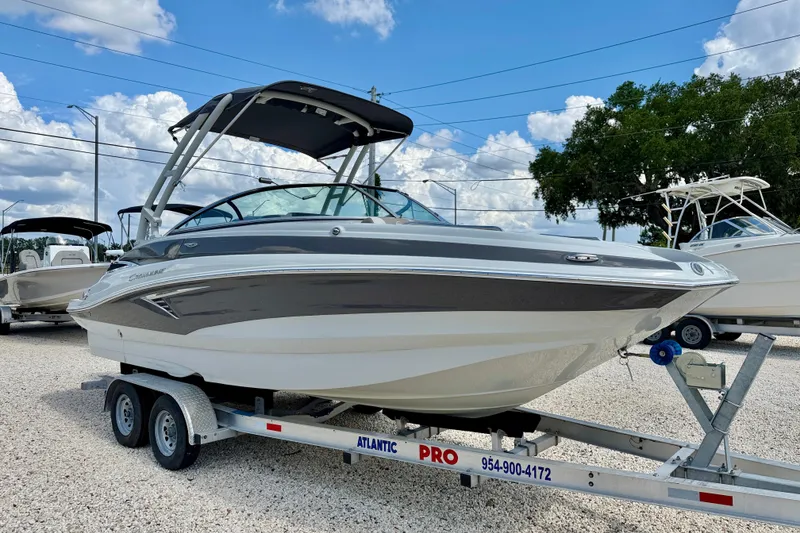 Slide: The Image of 2023 Crownline Eclipse E235 XS boat on trailer, parked outdoors under blue sky. - 3