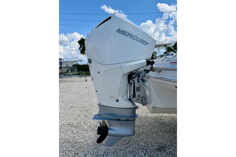 Slide: The Image of 2023 Crownline Eclipse E235 XS with Mercury outboard motor, parked on gravel under blue sky. - 36