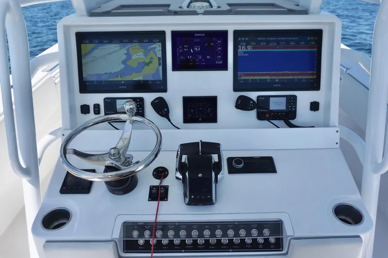Slide: The Image of Control panel of 2023 Invincible 36 Open Fisherman with navigation screens and steering wheel. - 33