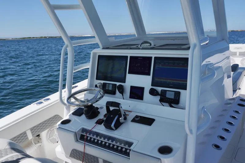 Slide: The Image of 2023 Invincible 36 Open Fisherman boat dashboard with advanced navigation systems on open water. - 36
