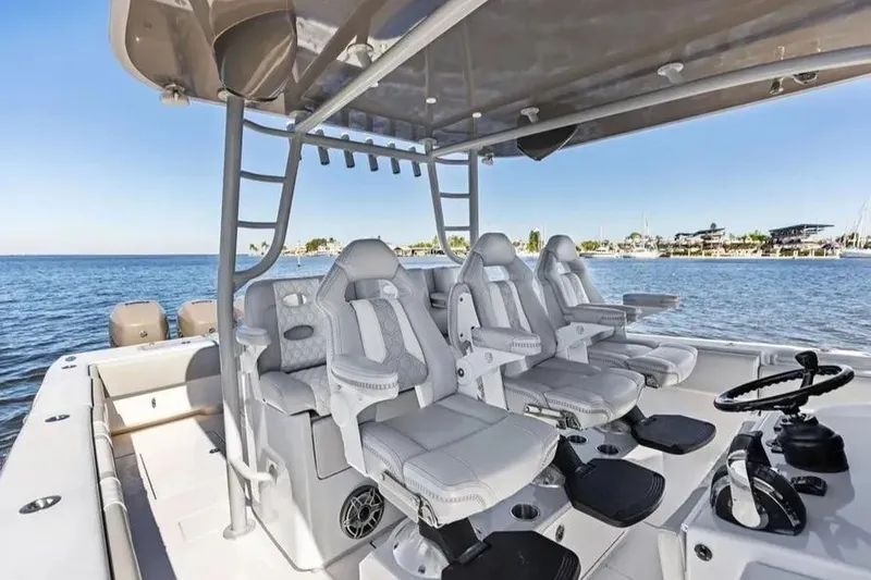 Slide: The Image of 2022 Contender 44 CB boat interior with luxurious seating and helm, overlooking serene waters. - 12