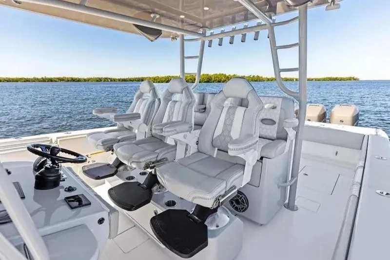 Slide: The Image of 2022 Contender 44 CB boat interior with luxurious seating and helm, overlooking serene waters. - 13