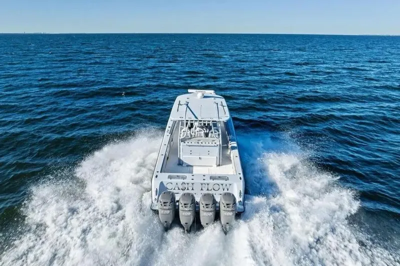 Slide: The Image of 2022 Contender 44 CB boat cruising on open ocean with four powerful engines. - 2