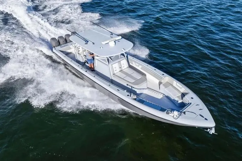 Slide: The Image of 2022 Contender 44 CB boat cruising on open water, showcasing sleek design and powerful engines. - 3