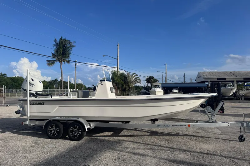 Slide: The Image of 2026 Sundance B22CCR boat on trailer, parked outdoors under clear blue sky. - 3