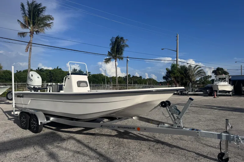 Slide: The Image of 2026 Sundance B22CCR boat on trailer, parked outdoors under clear blue sky. - 4