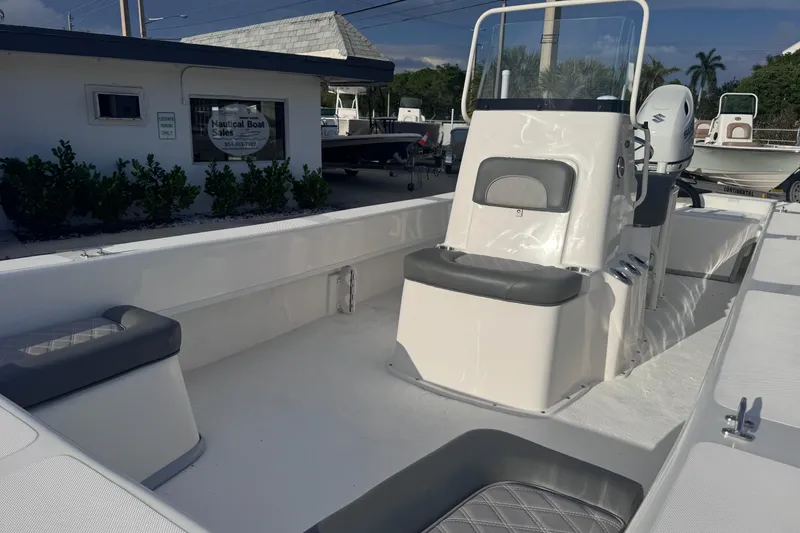 Slide: The Image of 2026 Sundance B22CCR boat interior with seating and console at a nautical sales location. - 6