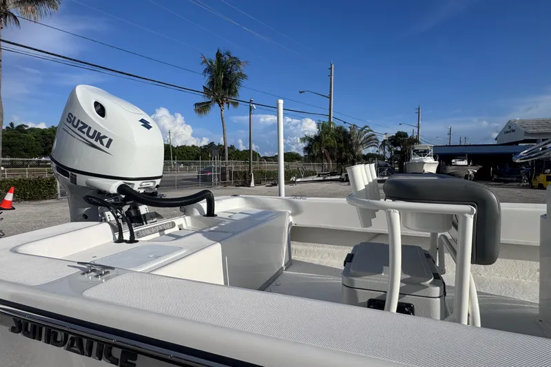 Slide: The Image of 2026 Sundance B22CCR boat with Suzuki outboard motor, docked under clear blue sky. - 8