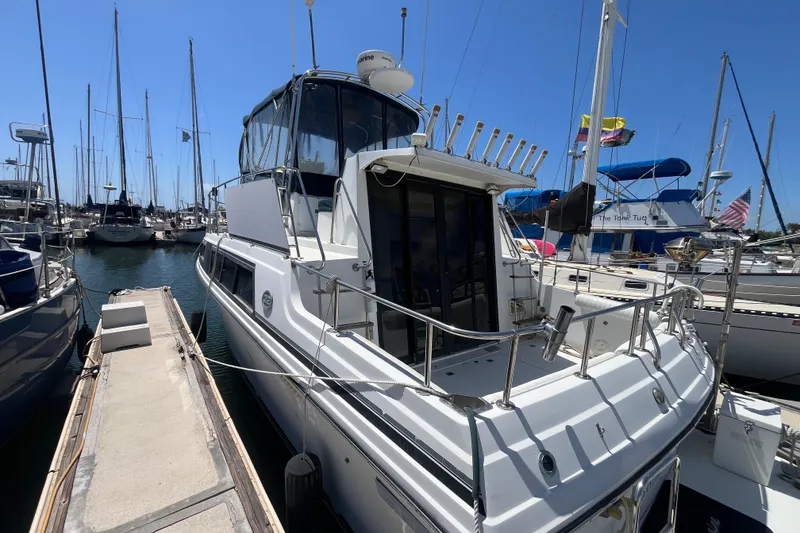 The Image of 1989 Carver 3297 Mariner yacht docked in a marina, surrounded by sailboats. - 0