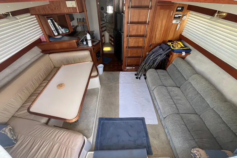 Slide: The Image of Interior of 1989 Carver 3297 Mariner yacht with cozy seating and wooden cabinetry. - 12