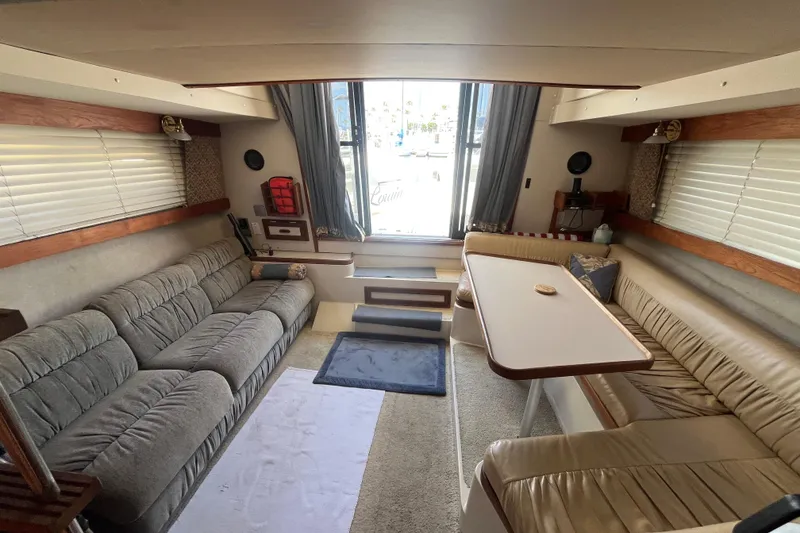 Slide: The Image of Interior of a 1989 Carver 3297 Mariner yacht with cozy seating and dining area. - 13