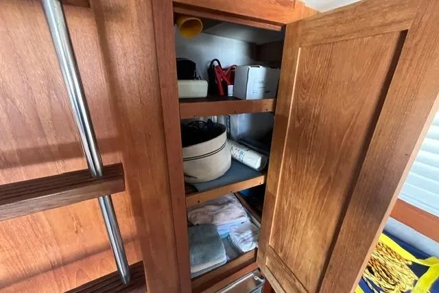 Slide: The Image of Wooden cabinet interior on a 1989 Carver 3297 Mariner boat, with shelves and various items. - 15