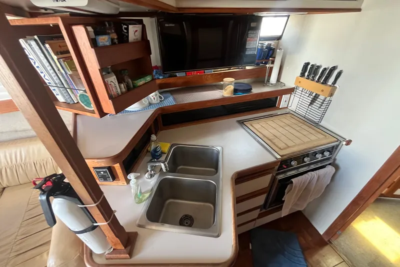Slide: The Image of 1989 Carver 3297 Mariner yacht kitchen with dual sinks, stove, and wooden cabinetry. - 16