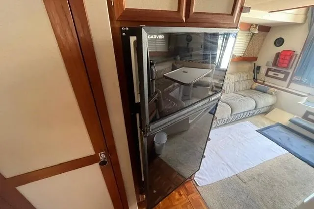 Slide: The Image of 1989 Carver 3297 Mariner interior with fridge and cozy seating area. - 17