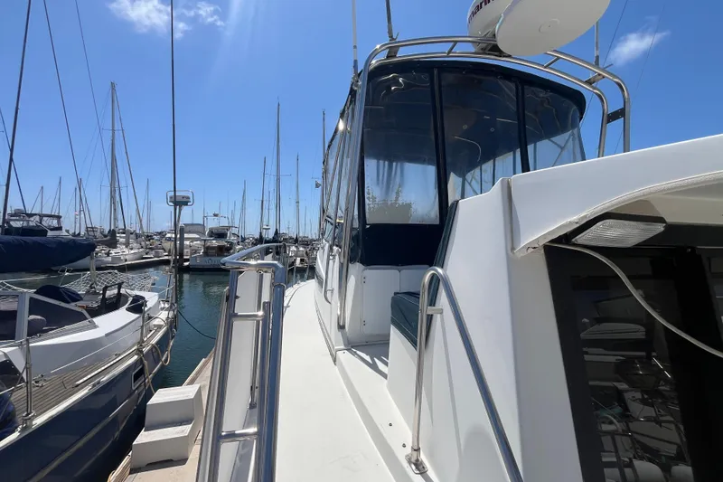 Slide: The Image of 1989 Carver 3297 Mariner yacht docked in a marina under clear blue sky. - 4