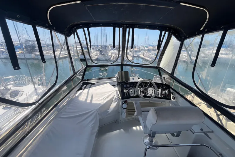 Slide: The Image of Interior view of 1989 Carver 3297 Mariner yacht helm with marina backdrop. - 8