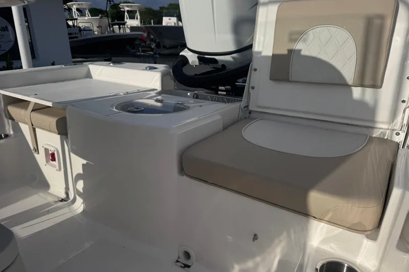 Slide: The Image of Interior of 2026 Sundance DX22 boat featuring beige seating and a compact sink area. - 11